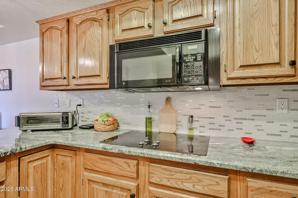 a kitchen with granite countertop a sink stainless steel appliances and cabinets