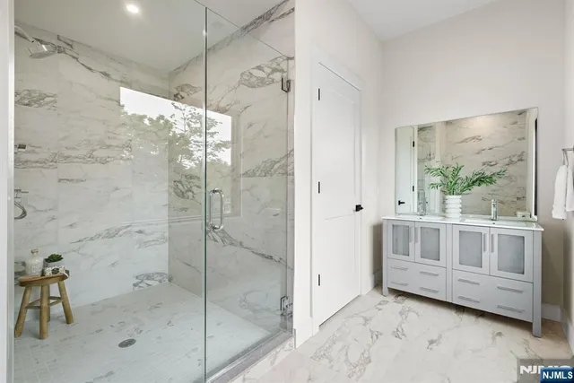 a bathroom with a glass shower door and a sink