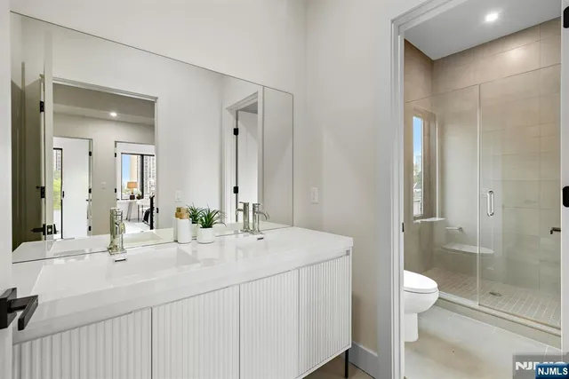 a bathroom with a sink a toilet and shower