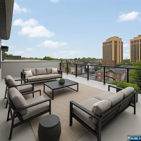 a roof deck with couches and potted plants