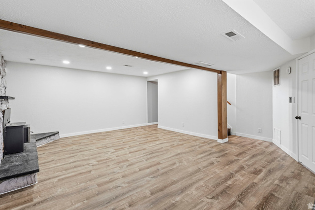 2693 Teal Way Sandy, UT 84093 - Photo 28 of 50 Spacious room featuring wood-finish flooring, recessed lighting, and a stone-clad fireplace with a dark mantel