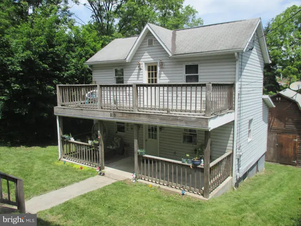 a view of a house with a yard and a deck