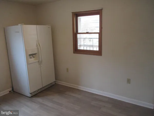 an empty room with wooden floor and window