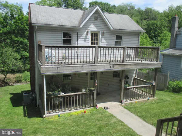 a front view of a house with a garden and yard