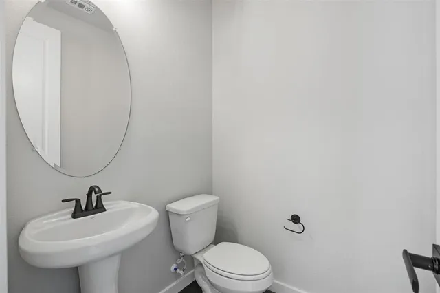 a bathroom with a sink a toilet and a mirror