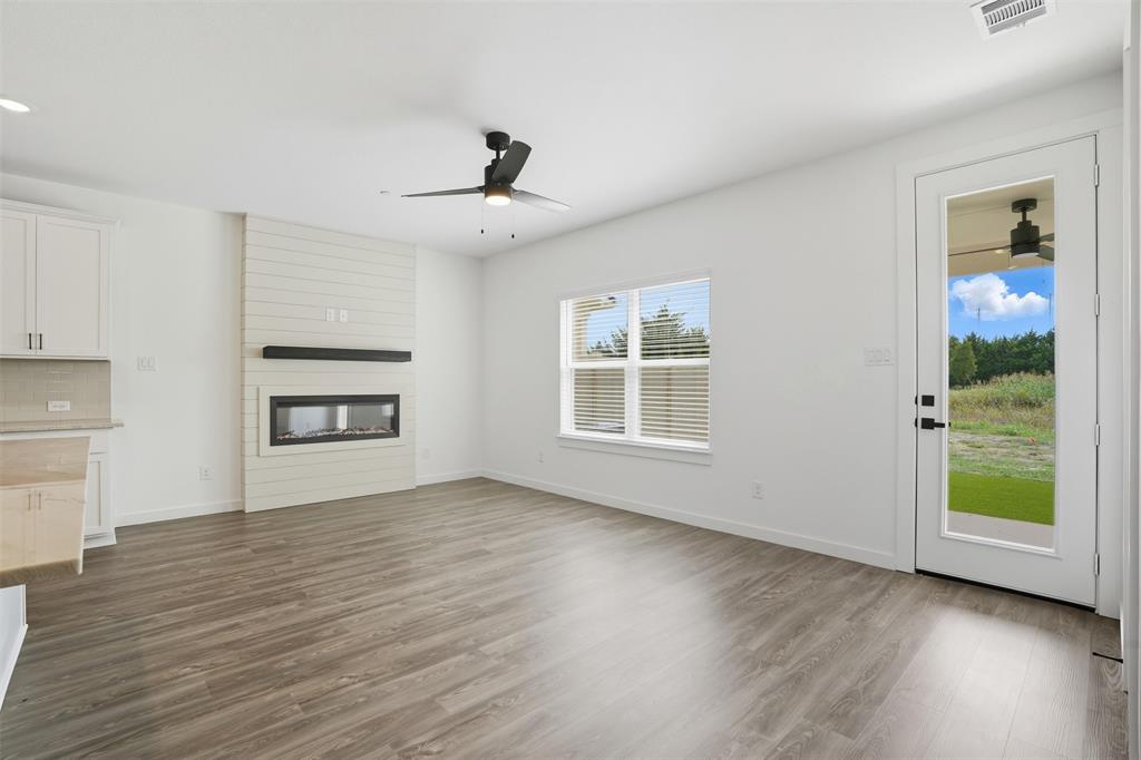 1622 Governors Boulevard Forney, TX 75126 - Photo 7 of 38 a view of an empty room with a window and wooden floor