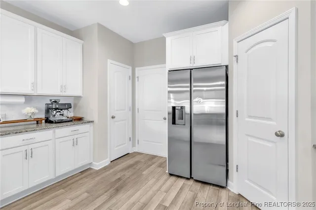 a kitchen with granite countertop a refrigerator and a sink