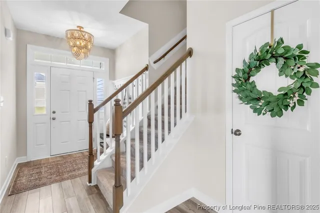 a view of a hallway with wooden floor and stairs