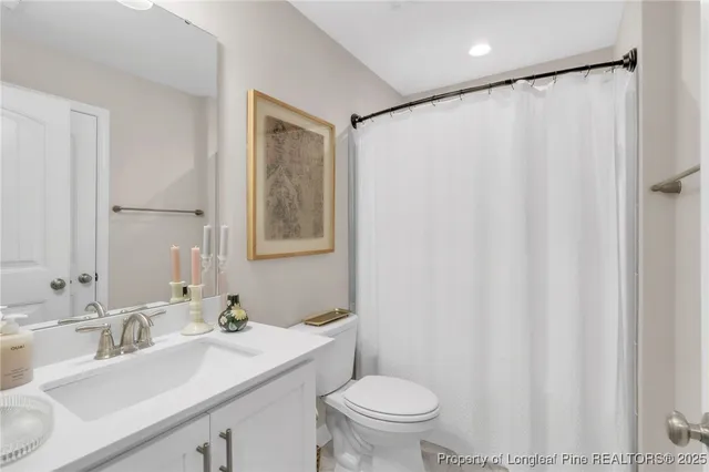 a bathroom with a sink mirror vanity and toilet