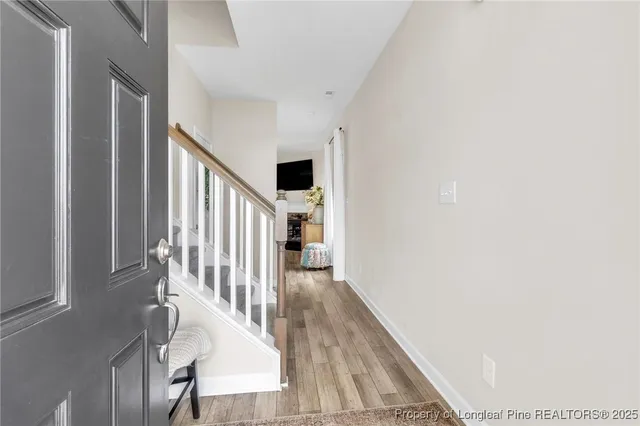 a view of a hallway with wooden floor and staircase