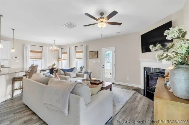a living room with furniture a fireplace and a chandelier