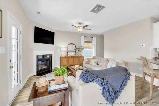 a living room with furniture a fireplace and a flat screen tv