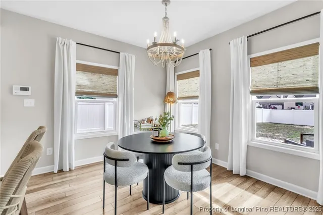 a dining room with furniture a chandelier and wooden floor