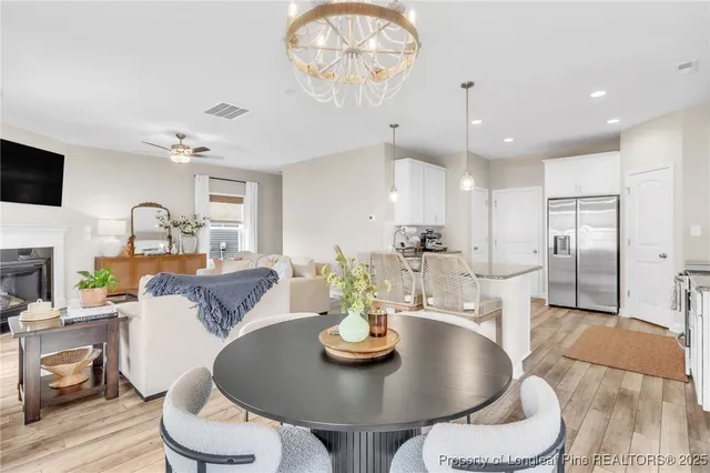 a view of a dining room with furniture a chandelier and wooden floor