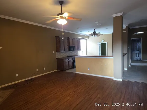 an empty room with wooden floor and chandelier