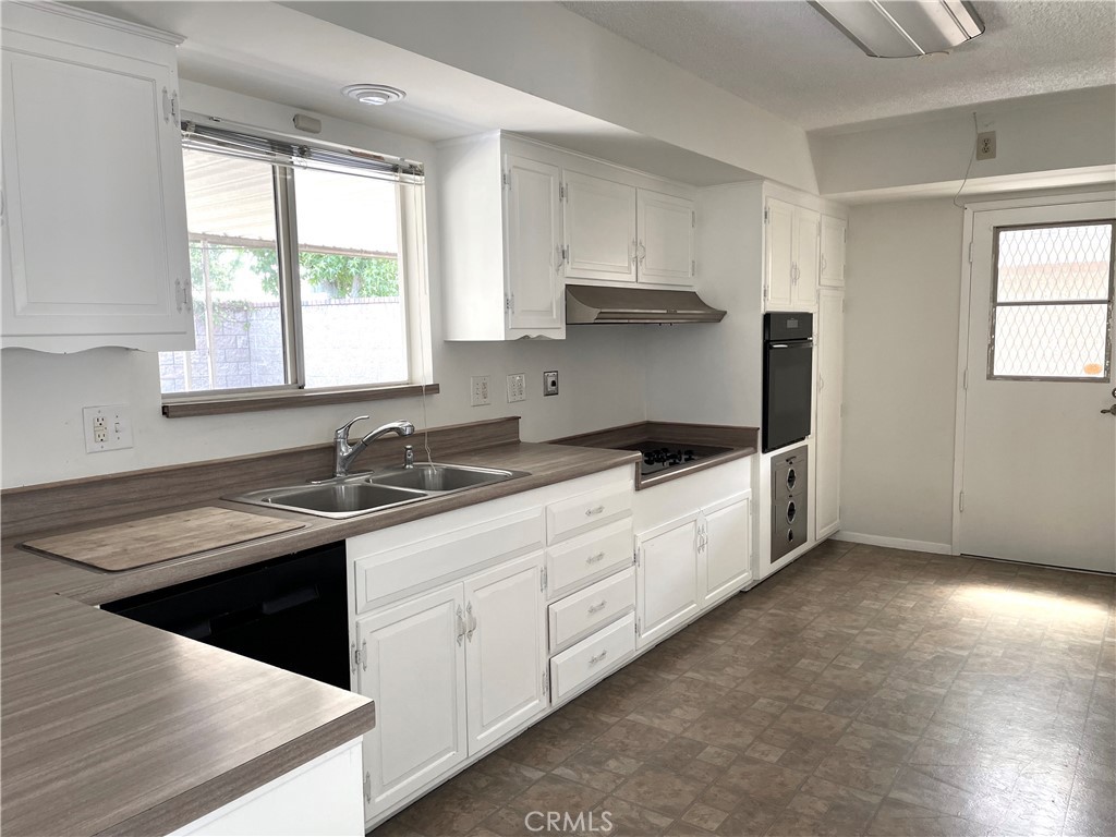 3001 Coleridge Drive Rossmoor, CA 90720 - Photo 5 of 25 a kitchen with a sink stove and cabinets