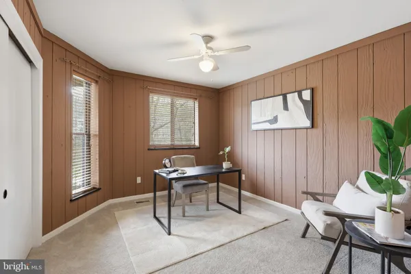 an empty room with a chandelier fan and closet