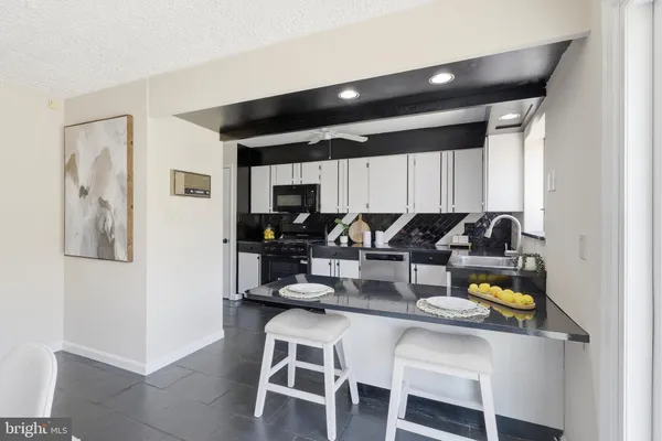 a kitchen with a dining table cabinets and stainless steel appliances