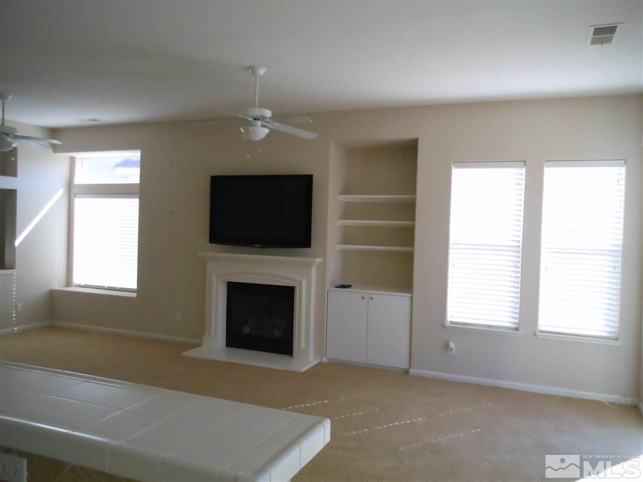 1624 Sewell Drive Reno, NV 89521 - Photo 2 of 14 a living room with a fireplace and a flat screen tv