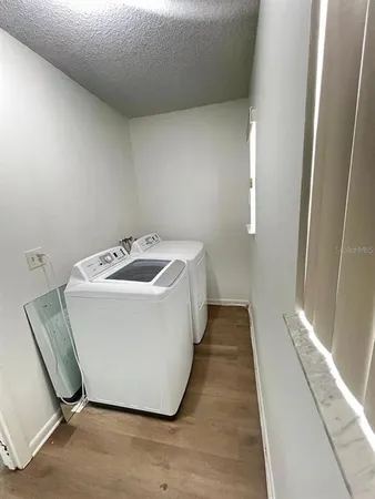 a utility room with wooden floor washer and dryer
