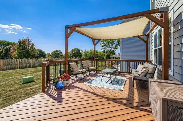a view of a rooftop deck with couch and chairs