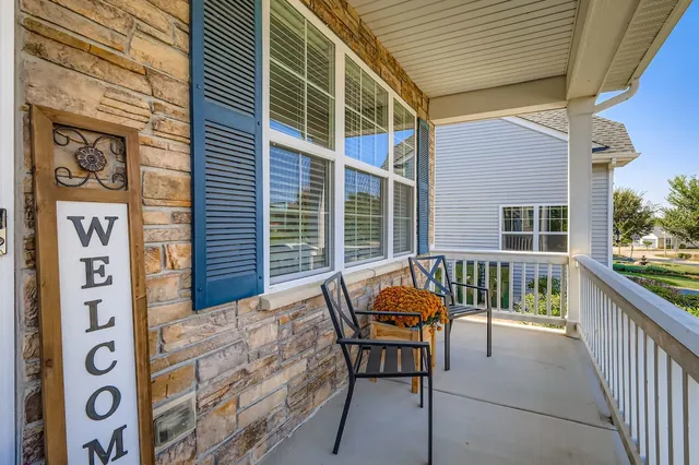 a balcony with furniture and next to a window