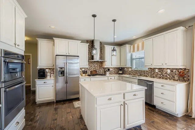 a kitchen with white cabinets and stainless steel appliances