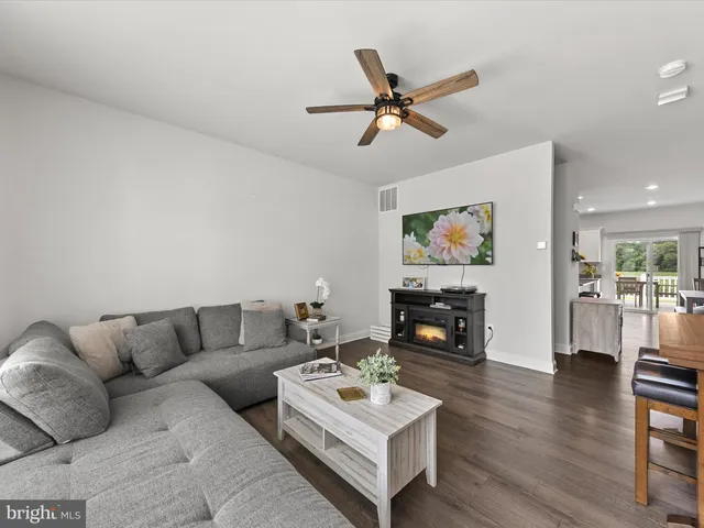 a living room with furniture and a flat screen tv with wooden floor