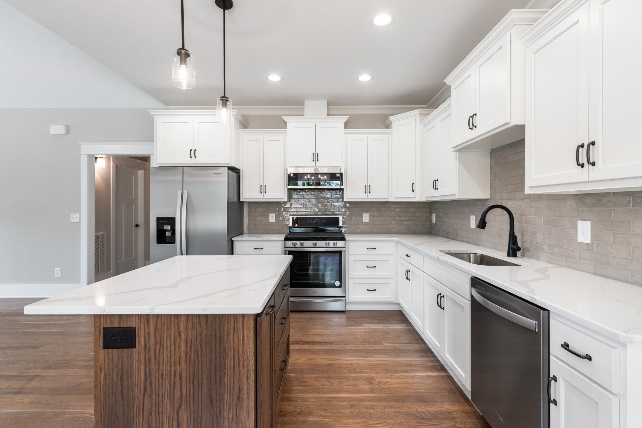 102 Mccreary Dickson, TN 37055 - Photo 10 of 31 a kitchen with stainless steel appliances kitchen island a refrigerator a sink dishwasher a stove and white cabinets with wooden floor