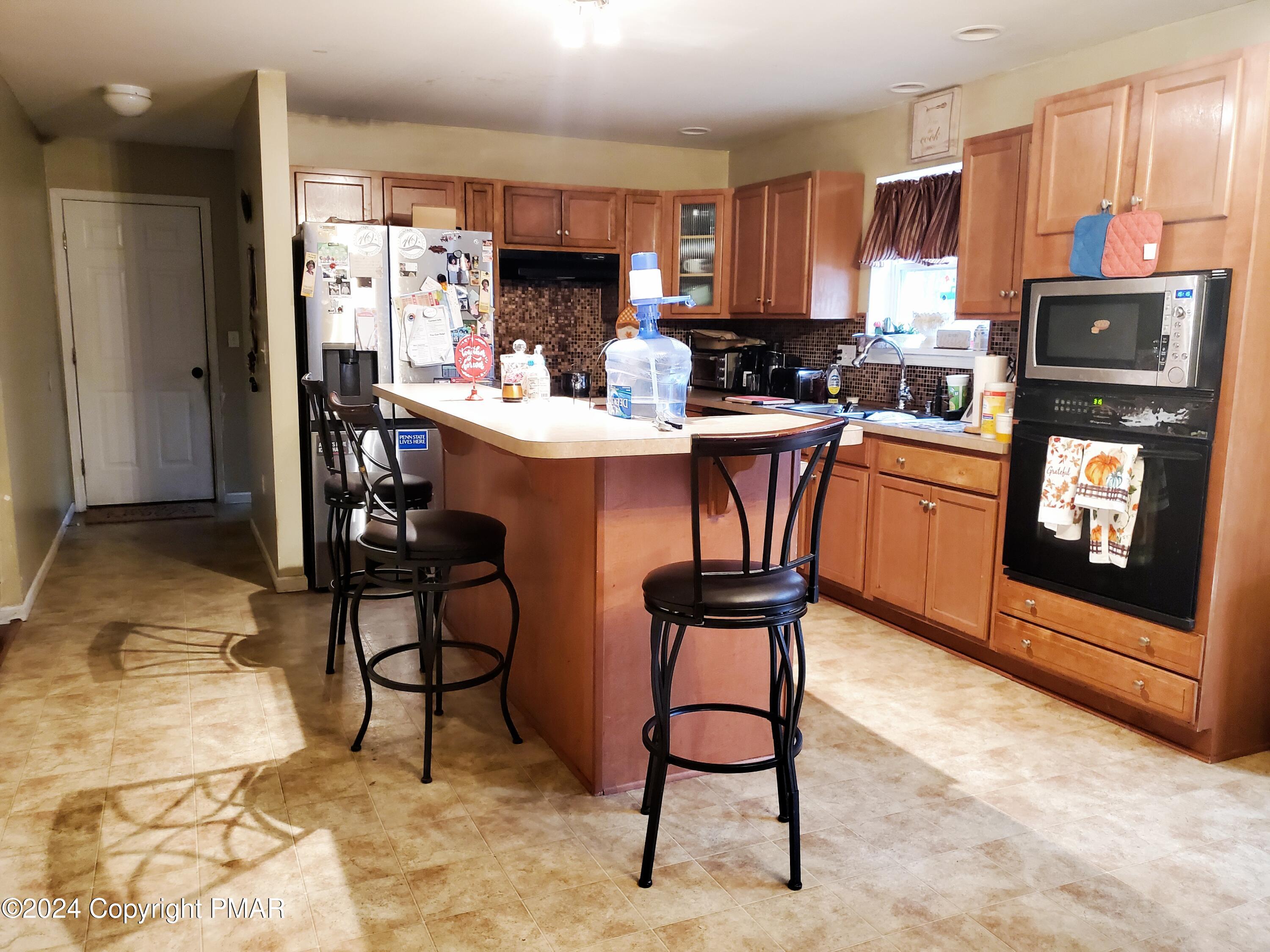 1102 Steele Circle Bushkill, PA 18324 - Photo 3 of 23 a kitchen with stainless steel appliances granite countertop a refrigerator a stove a sink and dishwasher