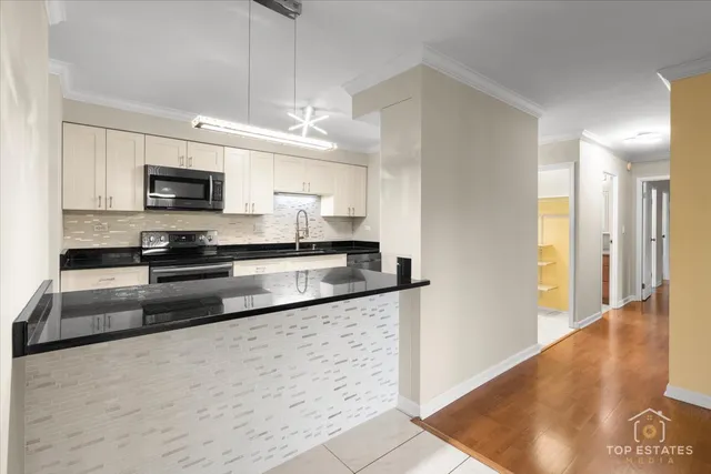a kitchen with granite countertop a refrigerator and a sink
