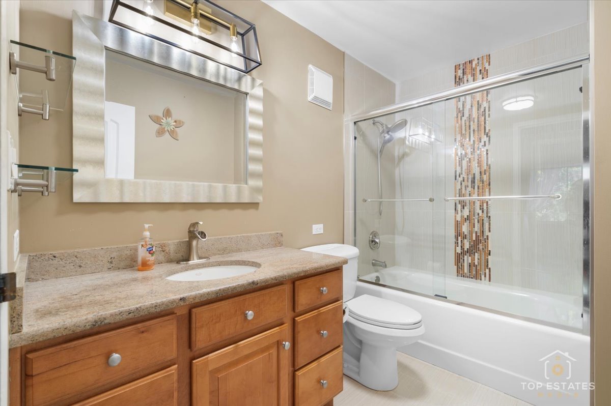 1615 East Central Road, Unit 218C Arlington Heights, IL 60005 - Photo 24 of 33 a bathroom with a granite countertop sink toilet and shower