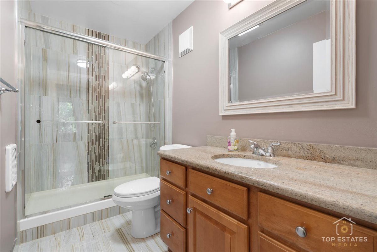 1615 East Central Road, Unit 218C Arlington Heights, IL 60005 - Photo 28 of 33 a bathroom with a granite countertop sink toilet and shower