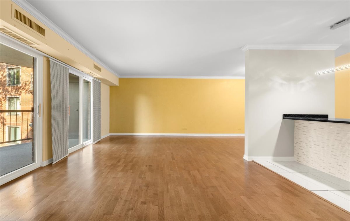 1615 East Central Road, Unit 218C Arlington Heights, IL 60005 - Photo 6 of 33 a view of an empty room with wooden floor and a window