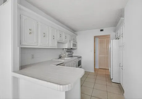 a kitchen with white cabinets stainless steel appliances and sink
