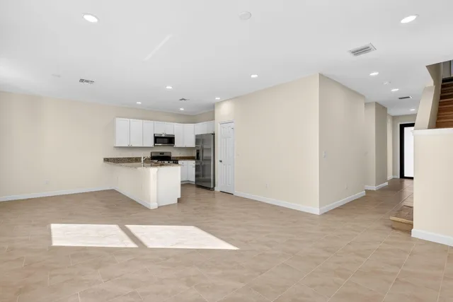 a kitchen with refrigerator and white cabinets