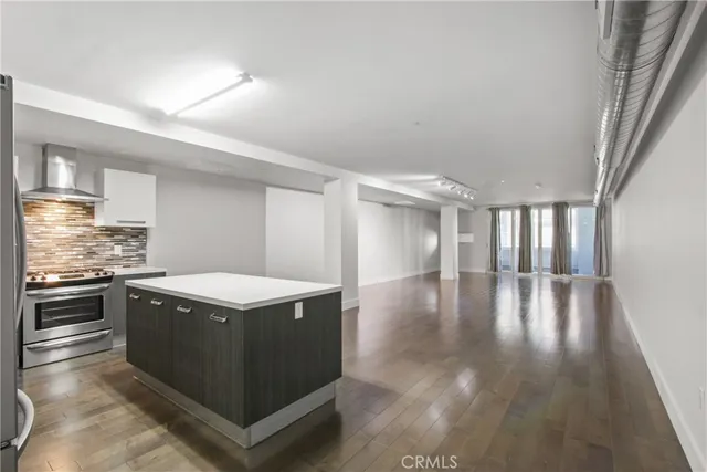a kitchen with a stove and wooden floor