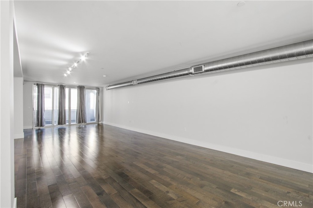 433 Pine Avenue, Unit 203 Long Beach, CA 90802 - Photo 5 of 19 a view of an empty room with wooden floor and a window