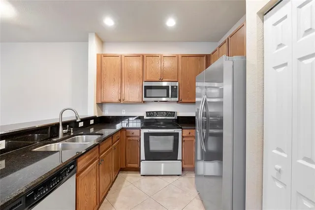 an empty room with wooden floor chandelier fan and windows