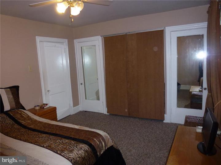 7028 Cresheim Road Philadelphia, PA 19119 - Photo 13 of 23 a bedroom with a bed and a lamp on dresser