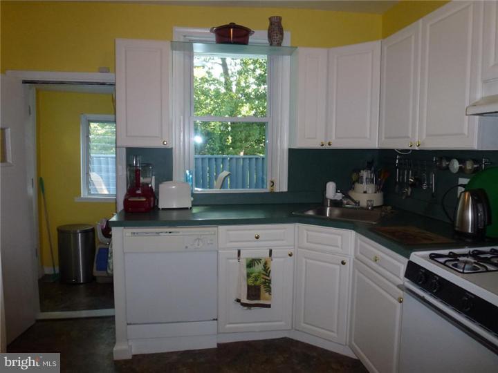7028 Cresheim Road Philadelphia, PA 19119 - Photo 9 of 23 a kitchen with stainless steel appliances a stove a white cabinets and a window