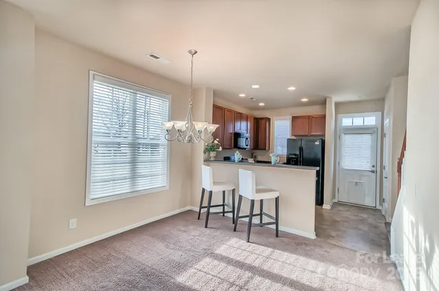 a open kitchen with stainless steel appliances kitchen island granite countertop a refrigerator and a sink