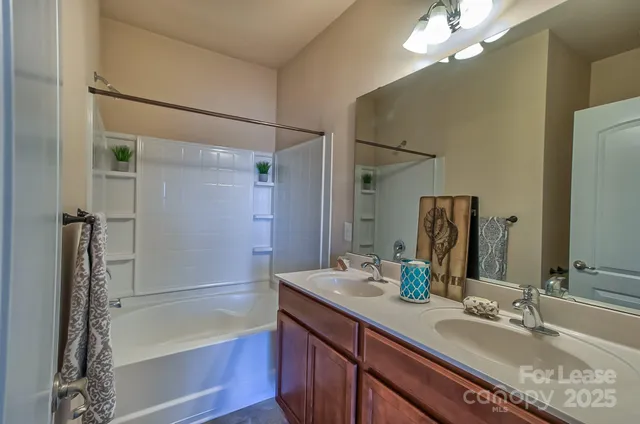 a bathroom with a tub sink and mirror