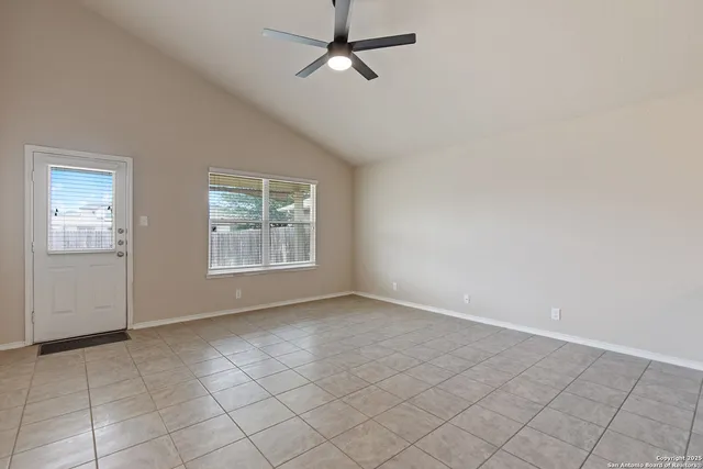 an empty room with windows and fan