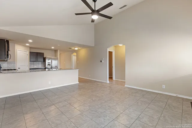 a view of an empty room and kitchen view