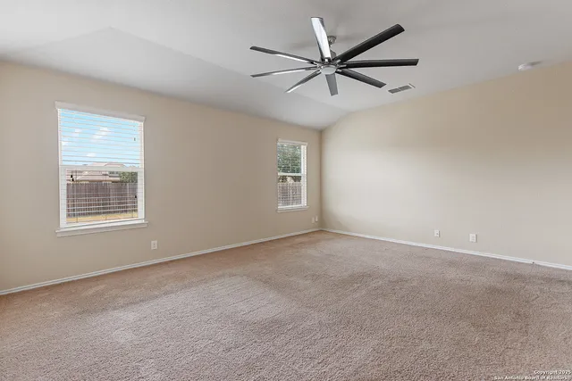 an empty room with windows and fan