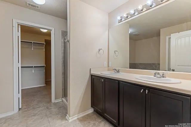 a bathroom with a double vanity sink and mirror