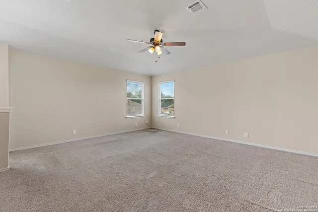 a view of a livingroom with a ceiling fan and window