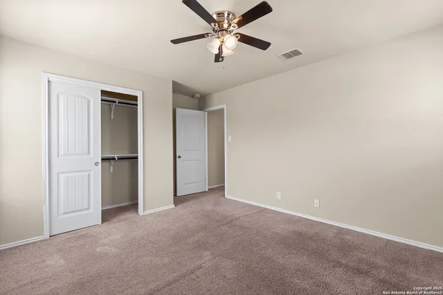 a view of an empty room and a ceiling fan