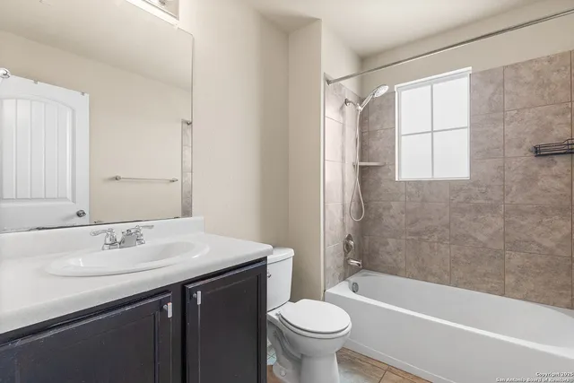 a bathroom with a sink toilet double vanity and bathtub